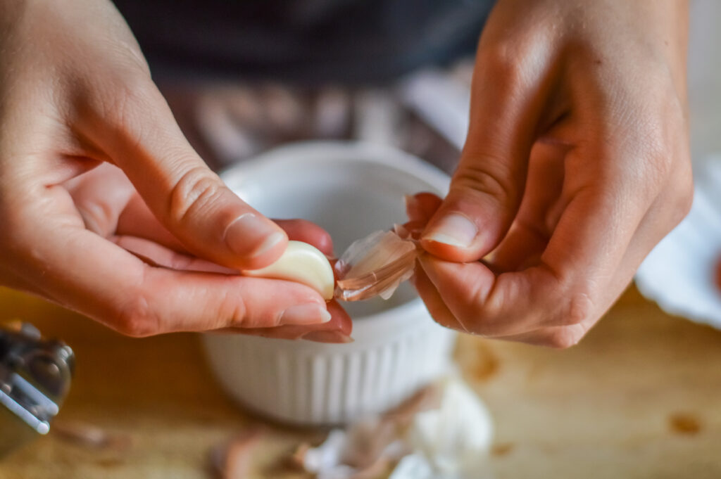 peeling garlic to make a cooking sauce close up