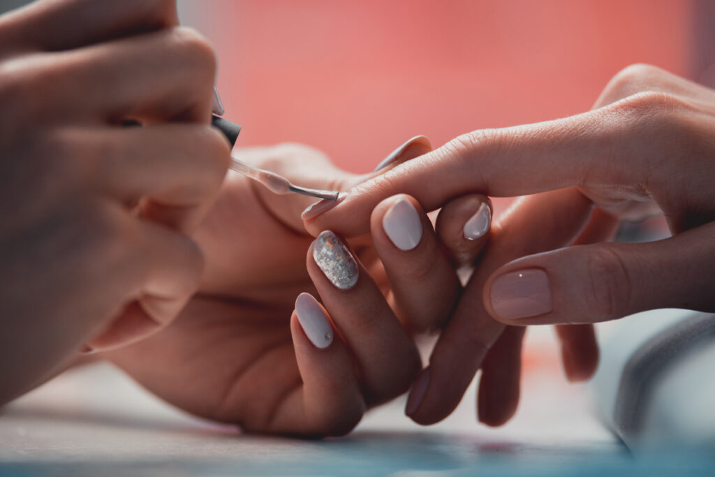 woman master arm applying lacquer in salon