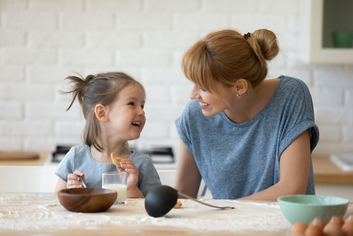 smiling,mother,looking,at,little,daughter,and,feeding,her,after