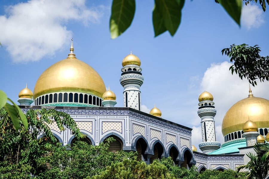 Building and tropical trees at the Jame'Asr Hassanil Bolkiah mosque in Brunei