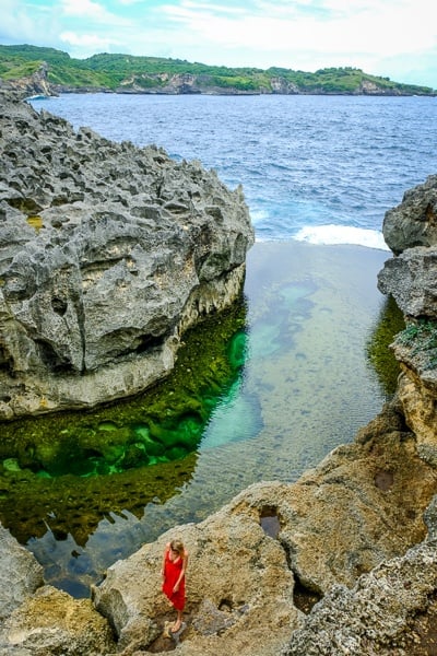 Tourist woman posing by Angel's Billabong tide pool in Nusa Penida, Bali